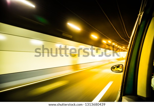 blur moving light in the tunnel from\
moving car at great speed. worm tone color\
image