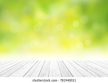 The Blur Nature Greenery Bokeh Leaf Wallpaper With White Wood Floor Foreground On Spring Autumn Park Background. Soft Focus Light View Leaves Flare. 