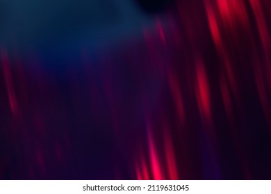 Blur neon background. Color glow. Light flare. Bokeh sparks texture. Defocused blue red purple flecks rays on dark abstract overlay.