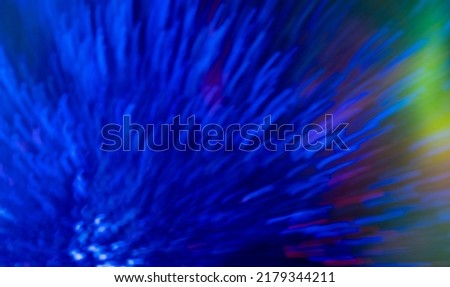 Blur neon glow. Bokeh light flare. Firework sparks. Defocused fluorescent navy blue explosion rays glare motion on rainbow colorful abstract background.