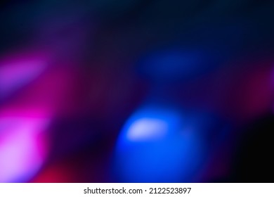 Blur neon light. Lens flare overlay. Bokeh fluorescent flash gleam. Defocused blue purple color flecks on dark black abstract background. - Shutterstock ID 2122523897