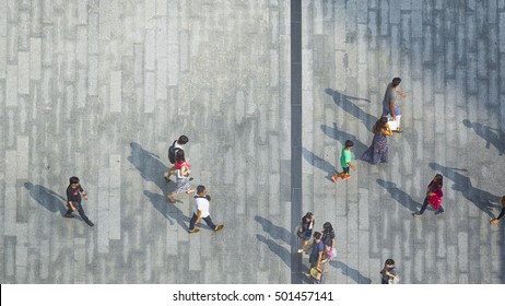 Blur People Are Going Across The Pedestrian Concrete Landscape In The City (Aerial Top View)