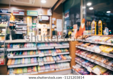 blur photo background of snacks and consumer product colorful in supermarket shop front shelf at counter cashier's desk. Mini-mart convenience stores are a new alternative for the urban people concept