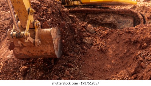Blur photo of backhoe working by digging soil at construction site. Bucket of backhoe digging soil. Crawler excavator digging on dirt. Excavating machine. Earth moving machine. Excavation vehicle.