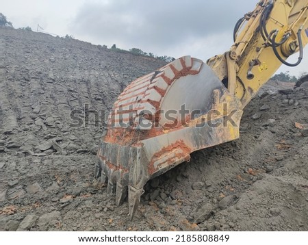 Blur photo of backhoe working by digging soil at construction site. Bucket of backhoe digging soil. Crawler excavator digging on dirt. Excavating machine. Earth moving machine. Excavation vehicle.