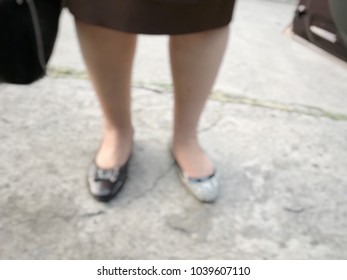 Blur Photo Of Fail / Funny Action : A Woman Wear Wrong Pair Of Shoe, One Is Brown While Another Side Is Black And White