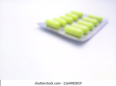 Blur Photo Of Green Medicine Capsule Package On White Background With Space For Text. Danger Eating Counterfeit Drugs. Copy Space. Healthy Concept