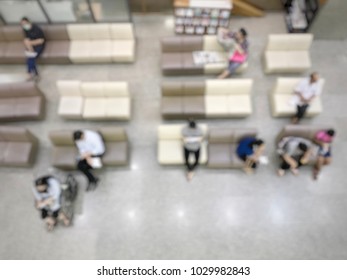 Blur Photo Of People Are Sitting On The White And Brown Chair (reading Book Or Magazine) Waiting For Calling On The Lobby In The Hospital, Top View