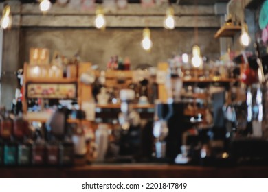 Blur Picture Of Coffee Shop Counter That Has Coffee Machine, Tea Bottle And Shelf. Decorate Light By Several Of Bulbs