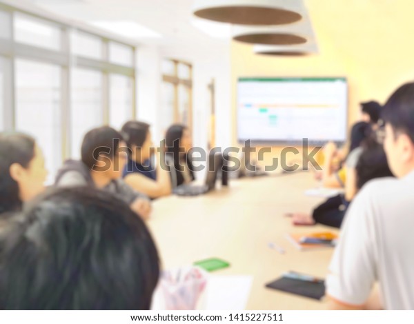 Blur picture, Teams member meeting at long table\
and background with projector and soft light, Group of professional\
business team discuss for conclusion, Concept teams work, building,\
success, growth