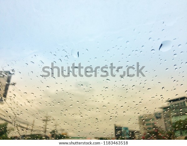 Blur, Rain drops on glass front mirror\
car on the road at\
Bangkok,Thailand.
