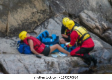 Blur. Search Rescue Emergency Response Team Rangers Provide Outdoor First Aid And Medical Treatment To Severely Injured National Park Visitor, Prepare Person For Evacuation To Hospital For Treatment