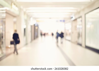 Blur Store With Bokeh Background. Silhouettes Of Business People In Blurred Motion Walking. Business People Walking In The Office Corridor.