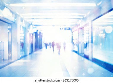 Blur Store With Bokeh Background. Silhouettes Of Business People In Blurred Motion Walking. Business People Walking In The Office Corridor.