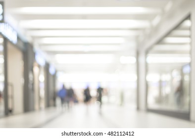 Blur Store With Bokeh Background. Silhouettes Of People In Blurred Motion Walking. Business People Walking In The Office Corridor.