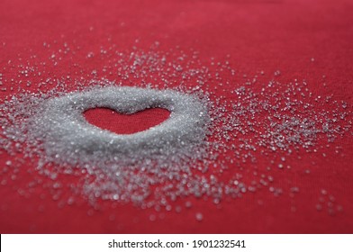 The blur of the sugar on the red cloth. The inside of it is hollow, it is a heart shape. The sugar looks swaying.
