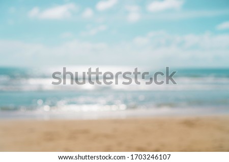 Blur summer bokeh beach with sun light and blue sky background.