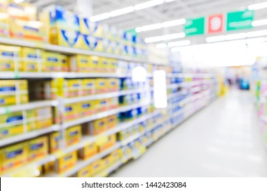 Blur Supermarket Aisle With Baby Formula Milk Powder Product On The Shelf Background,Many Milk Powder Brand Sale On The Shelf In A Supermarket, As Blurred Effect Background, Baby Milk Powder Section.