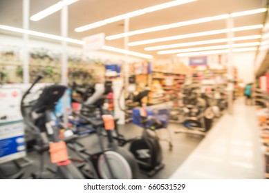 Blur Variety Of Fitness Equipment On Display At Sporting Goods Store In Houston, Texas, US. Defocused Pile Of Dumbbells, Weight, Strength Training, Stepper, Cardio Machine, Gym Room. Customer Shopping