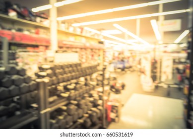 Blur Variety Of Fitness Equipment On Display At Sporting Goods Store In Houston, Texas, US. Defocused Pile Of Dumbbells, Weight, Strength Training, Stepper, Cardio Machines, Gym Service. Vintage Tone.