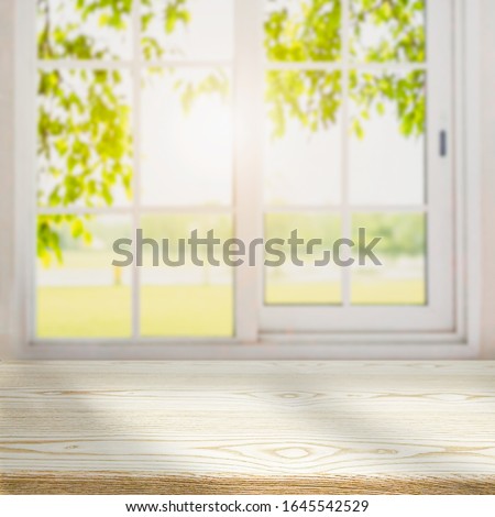 blur wooden table in the kitchen on the window background in the morning.

