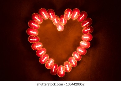 Blur Zoom Effect Of Top View Round Red Candles Glow In The Dark Forming  In Heart Shape At Night Time On Dark Background. Valentine's Day Concept.