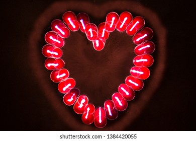 Blur Zoom Effect Of Top View Round Red Candles Glow In The Dark Forming  In Heart Shape At Night Time On Dark Background. Valentine's Day Concept.