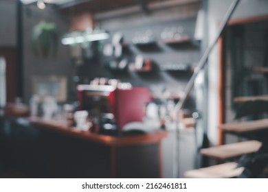 Blured Background Front View Of Coffee Shop Or Cafe Bar Restaurant Nobody Indoor. Empty Coffee Shop Interior Daytime With Wooden Design Counter Cement Wall In Background.