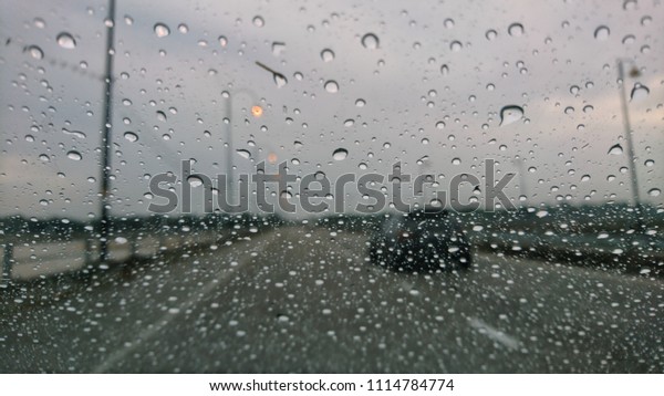 Blured background with rains drop on glass and\
cars on the road, Road view through car window blurry with heavy\
rain, Driving in rain, rainy\
weather