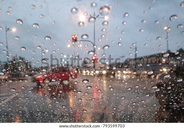 Blured background with rains drop on glass\
and cars on the road, Road view through car window blurry with\
heavy rain, Driving in rain, rainy\
weather\
\
