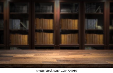 Blured Bookshelf In Small Home Library In The Background. Table Top For Product Display Montage. Dark Interior Design.