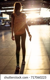 Blured image. back view of young woman in the hall of the airport terminal with a passport and boarding pass. silhouette of a woman in a bracing light.