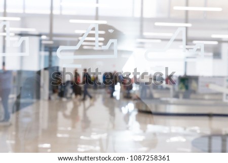 Blured image of people waiting for their suitcases on luggage conveyor belt in the baggage claim at airport arrival hall. Airline traveling concept.