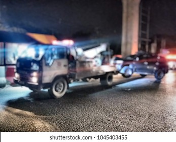 Blured Police Department Tow Truck Are Towing Accident Vehicle On The Road At Night