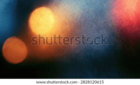 Blurred abstract background featuring glowing bokeh lights in warm orange and cool blue hues, creating a dreamy and atmospheric effect.