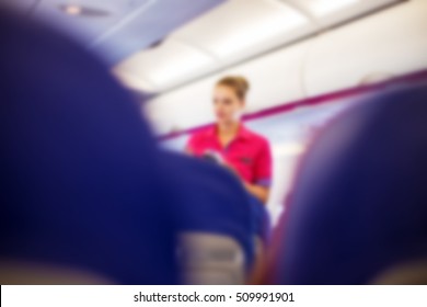 Blurred Abstract Background Of Flight Attendant Serving Passengers On The Plane.