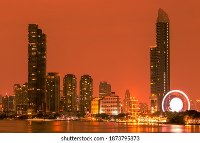 Blurred abstract background of high-rise buildings built by the river, lit at night, the distribution of residences of today's capital society. - Shutterstock ID 1873795873