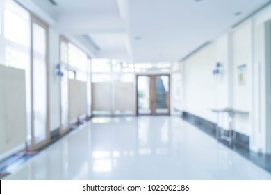 Blurred abstract background interior view looking out toward to empty office lobby and entrance doors and glass curtain wall with frame - blue white balance processing style - Shutterstock ID 1022002186