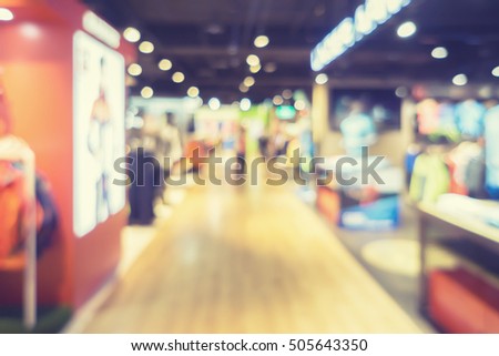 blurred abstract background of multi colored cotton clothing on the shelves of fashion and shoe shop in city shopping mall people crowd at marketplace.vintage color