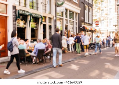 Blurred abstract background of outdoor cafe in Amsterdam. Outdoor cafe with tables, chairs and tourist at the old town.
