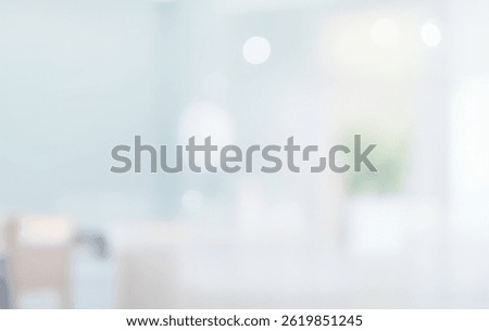 Blurred abstract background with soft light tones and a plant silhouette.