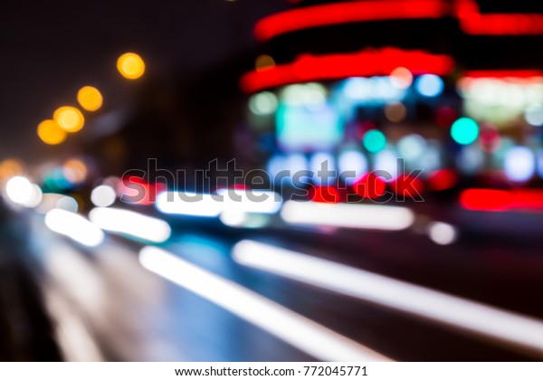 Blurred abstract\
background. The street lights in a blur. Evening or night city.\
Light of shop Windows and\
cars.