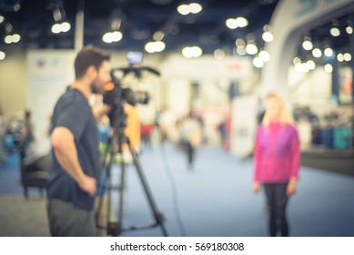 Blurred Abstract Of Cameraman Operator And Assistant Recording/videotaping An Interview With A Fit And Lifestyle Female Athlete Runner At The Conventional Hall Of Marathon Event Expo. Vintage Tone.