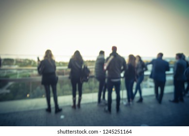 Blurred Abstract Diverse Group Of People In Formal Dress Hanging Out At Rooftop Bar In Downtown Chicago, USA. Business Happy Hour Concept, Autumn Season