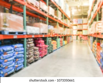 Blurred Abstract Dog And Cat Food Shelves In Modern Distribution Warehouse Or Storehouse. Defocused Pet Food Aisle Wholesale From Floor To Ceiling. Customer Shopping