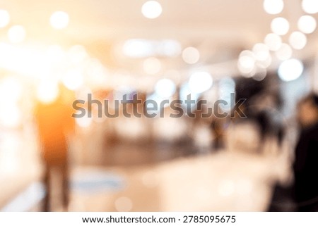 A blurred abstract image featuring a soft bokeh effect in a city background, dominated by warm white and cream lights emanating from the left.