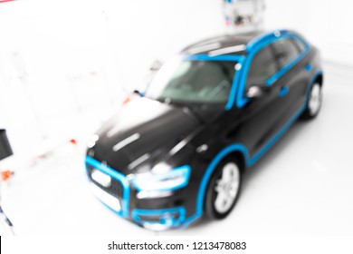 Blurred Abstract Image Of Man Worker With Car In Body Shop. Blur Car Auto Service. Car Bokeh. Blurred Background With Car In Garage. Vehicle Maintenance In Auto Repair Service. Blurry Service Station