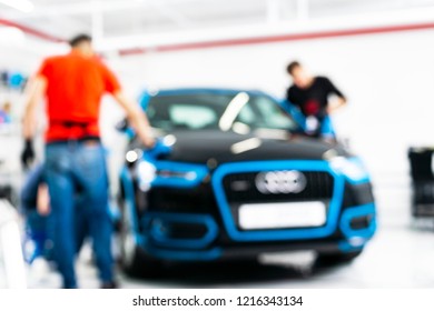 Blurred Abstract Image Of Man Worker With Car In Body Shop. Blur Car Auto Service. Car Bokeh. Blurred Background With Car In Garage. Vehicle Maintenance In Auto Repair Service. Blurry Service Station