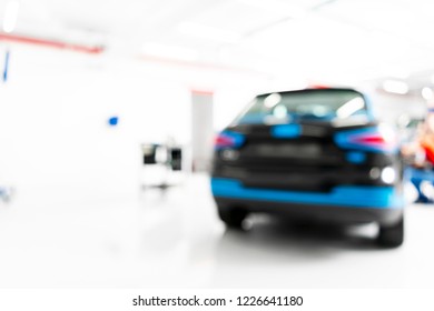 Blurred Abstract Image Of Man Worker With Car In Body Shop. Blur Car Auto Service. Car Bokeh. Blurred Background With Car In Garage. Vehicle Maintenance In Auto Repair Service. Blurry Service Station