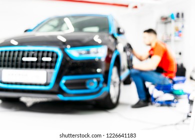 Blurred Abstract Image Of Man Worker With Car In Body Shop. Blur Car Auto Service. Car Bokeh. Blurred Background With Car In Garage. Vehicle Maintenance In Auto Repair Service. Blurry Service Station